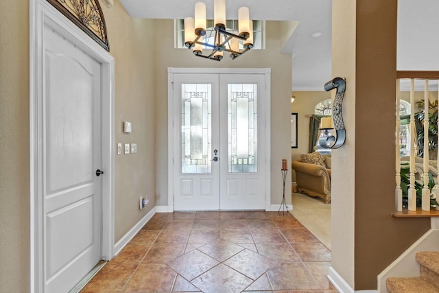 foyer entrance with an inviting chandelier, french doors, and light tile patterned flooring