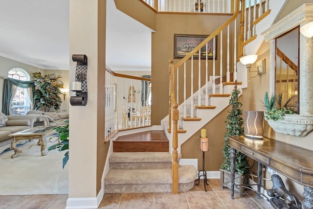 staircase with ornamental molding and tile patterned flooring