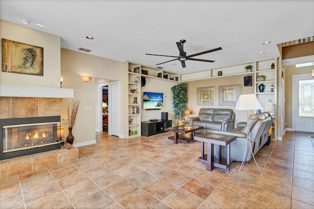 living room featuring a tile fireplace and ceiling fan