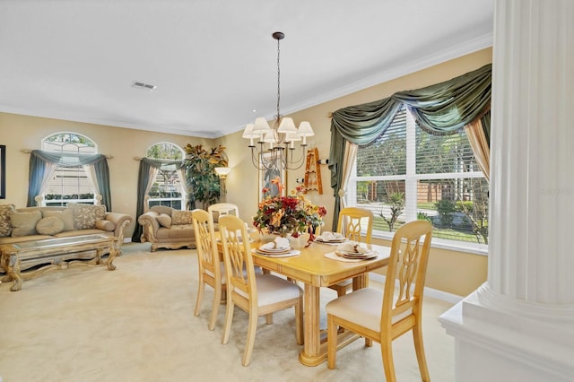 carpeted dining area featuring crown molding, plenty of natural light, and a notable chandelier