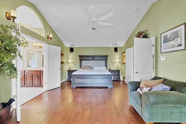 bedroom with hardwood / wood-style flooring, ceiling fan with notable chandelier, and high vaulted ceiling