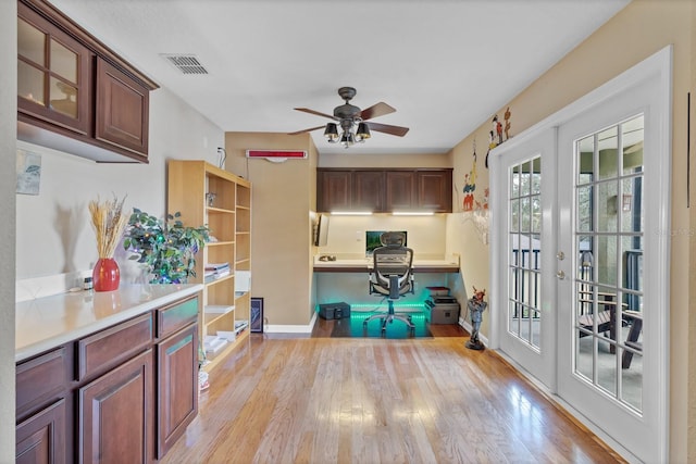 kitchen with ceiling fan, built in desk, light hardwood / wood-style floors, and french doors