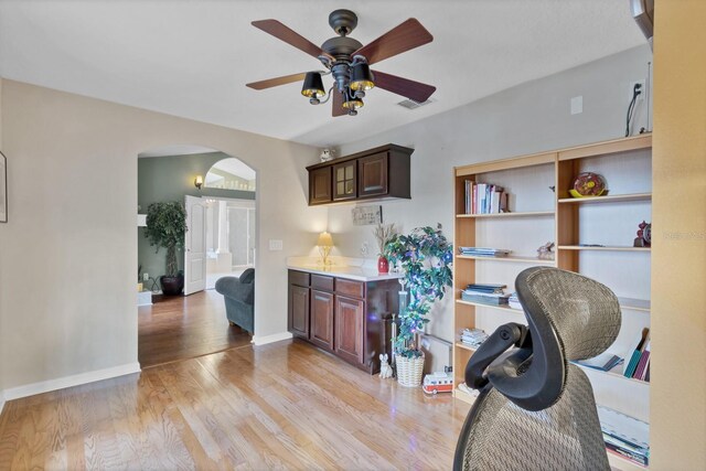 office with light hardwood / wood-style flooring and ceiling fan