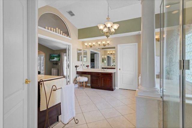 bathroom featuring vanity, vaulted ceiling, tile patterned floors, a chandelier, and ornate columns