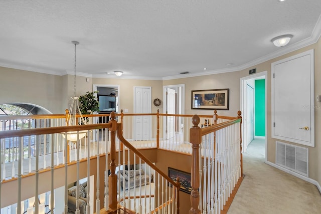 hall featuring ornamental molding, light colored carpet, and a textured ceiling