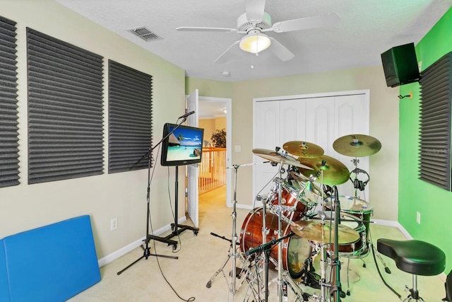 playroom with ceiling fan and a textured ceiling