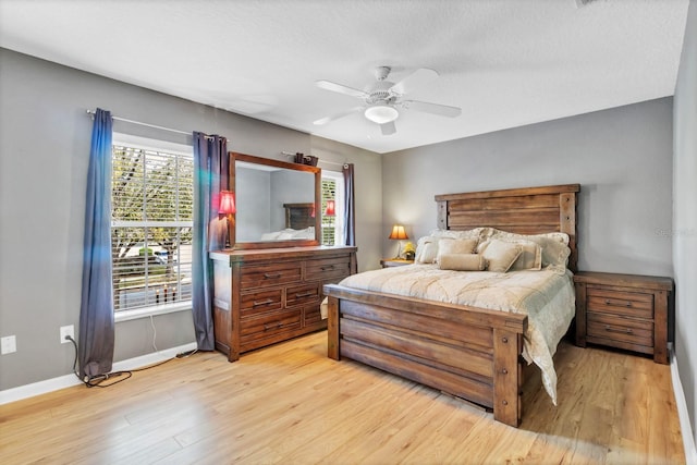 bedroom featuring a textured ceiling, ceiling fan, and light hardwood / wood-style flooring