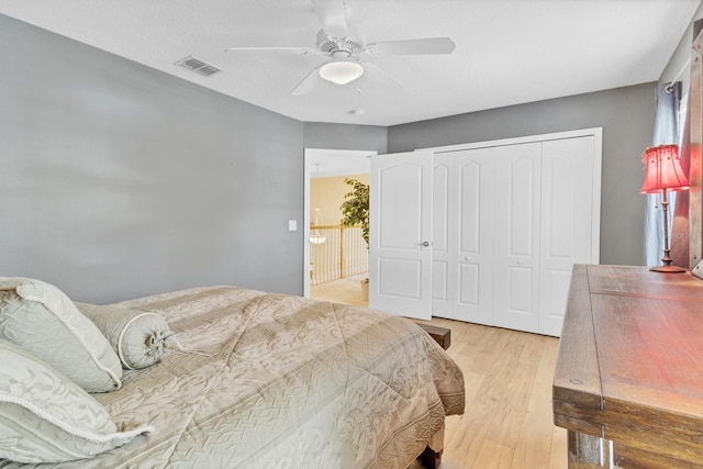 bedroom with light hardwood / wood-style floors, a closet, and ceiling fan