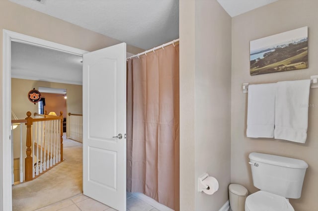 bathroom featuring tile patterned floors, toilet, and walk in shower