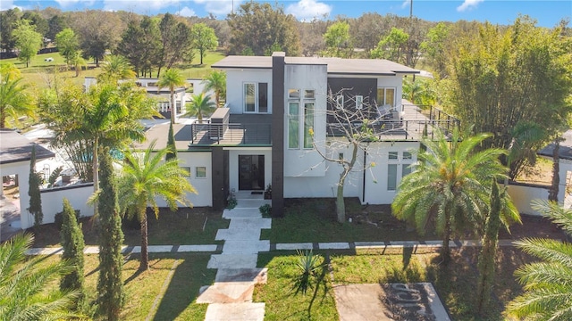 view of front of house with a balcony and stucco siding