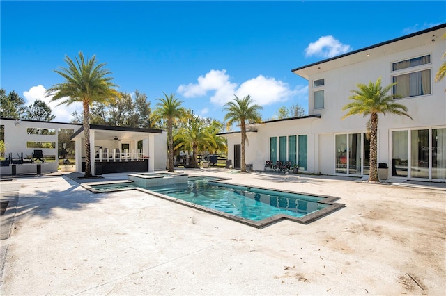 view of pool featuring a pool with connected hot tub, a patio, and ceiling fan