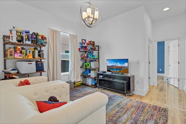 living room featuring recessed lighting, a notable chandelier, baseboards, and wood finished floors