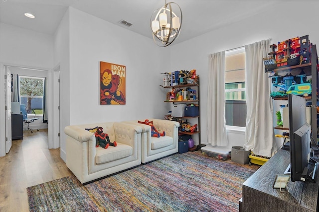 living room with recessed lighting, wood finished floors, visible vents, and a notable chandelier