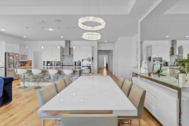 dining room featuring light wood-style floors, recessed lighting, and an inviting chandelier