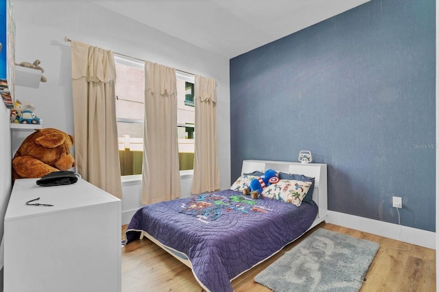 bedroom featuring wood finished floors and baseboards