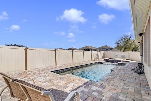 view of swimming pool featuring a patio area, a fenced backyard, and a pool with connected hot tub