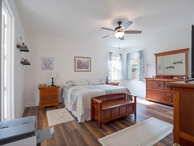 bedroom featuring dark wood-style flooring, a ceiling fan, and baseboards