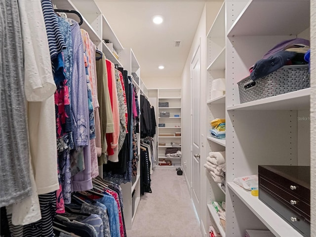 walk in closet featuring light carpet and visible vents