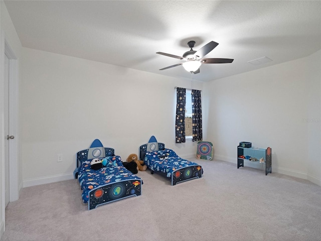 bedroom featuring baseboards, visible vents, a ceiling fan, and light colored carpet