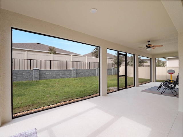 unfurnished sunroom featuring ceiling fan