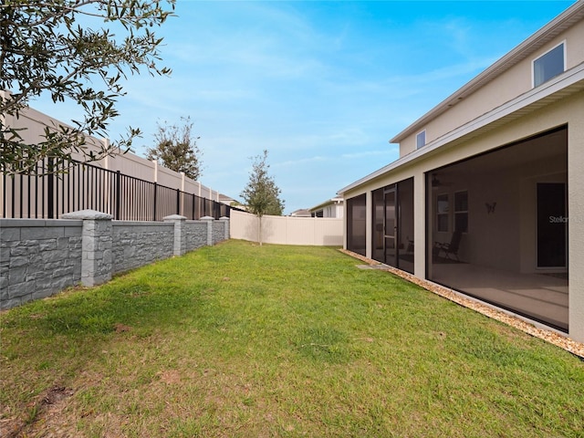 view of yard featuring a sunroom and a fenced backyard