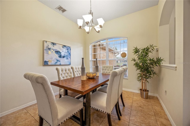 tiled dining room featuring a chandelier