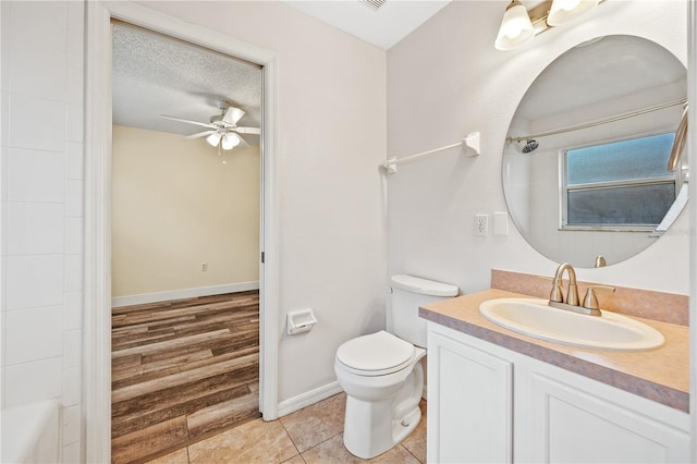 bathroom with ceiling fan, tile patterned flooring, vanity, a textured ceiling, and toilet