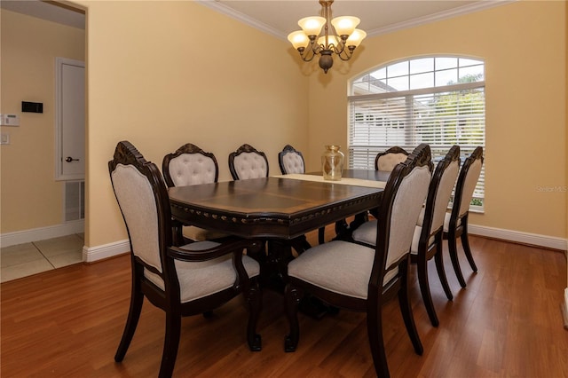 dining room with an inviting chandelier, ornamental molding, and dark hardwood / wood-style floors