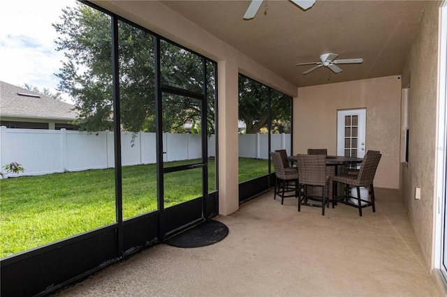 sunroom featuring a healthy amount of sunlight and ceiling fan