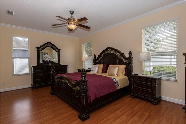 bedroom with ceiling fan, ornamental molding, and wood-type flooring