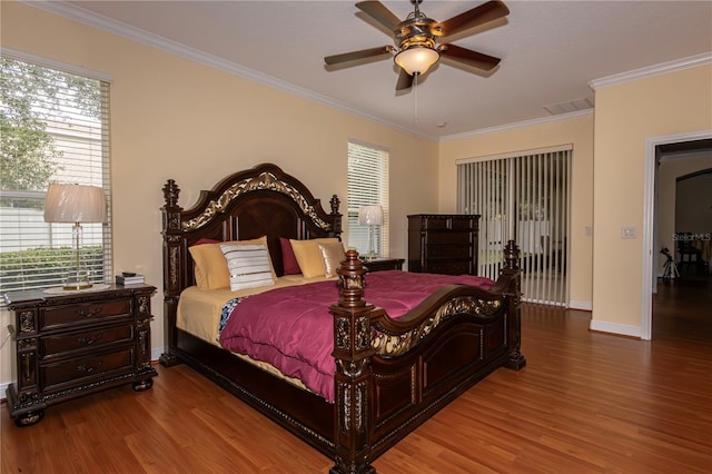 bedroom featuring ornamental molding, hardwood / wood-style floors, and multiple windows