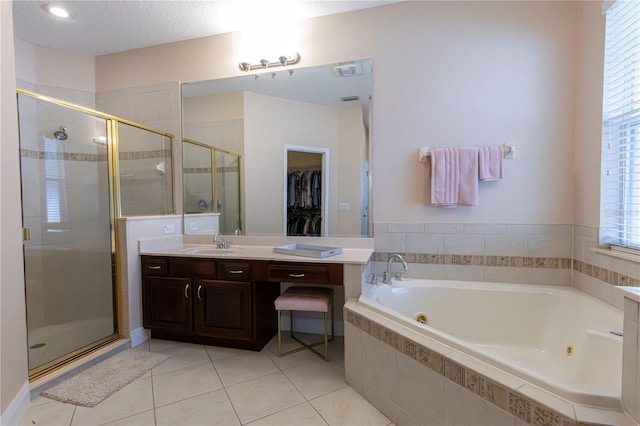 bathroom featuring vanity, separate shower and tub, tile patterned flooring, and a textured ceiling