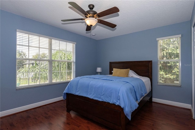 bedroom featuring ceiling fan, a textured ceiling, and dark hardwood / wood-style flooring