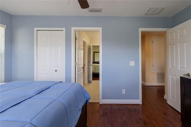 bedroom featuring ceiling fan, ensuite bathroom, a textured ceiling, dark hardwood / wood-style flooring, and a closet