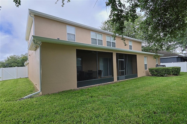 rear view of property with a sunroom and a lawn