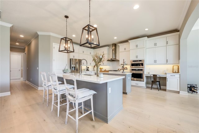 7515 John Hancock Dr, Winter Garden, FL 34787 - kitchen with an inviting chandelier, wall chimney range hood, crown molding, a center island with sink, and stainless steel appliances