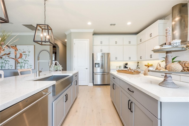 7515 John Hancock Dr, Winter Garden, FL 34787 - kitchen featuring pendant lighting, ornamental molding, visible vents, appliances with stainless steel finishes, and light wood finished floors