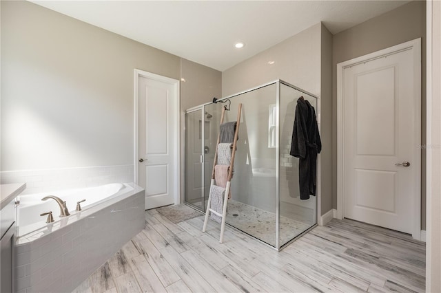 7515 John Hancock Dr, Winter Garden, FL 34787 - bathroom featuring a shower stall, wood finished floors, and a garden tub