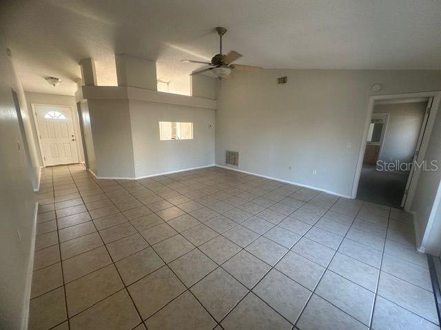 spare room with light tile patterned floors, ceiling fan, and visible vents