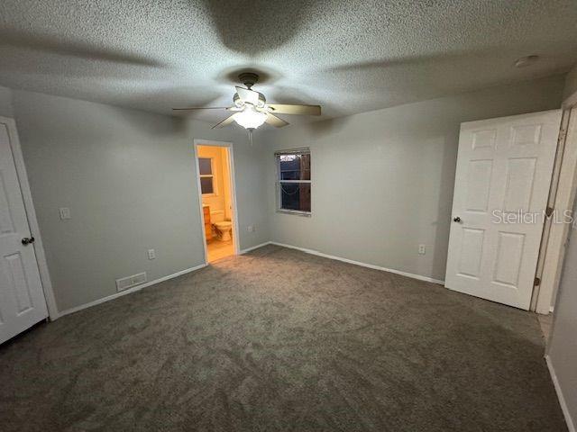 unfurnished bedroom with carpet floors, visible vents, and baseboards