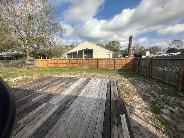 wooden deck featuring a fenced backyard and a yard