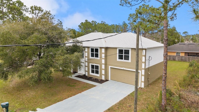 view of front of property featuring stucco siding, concrete driveway, fence, a garage, and a front lawn