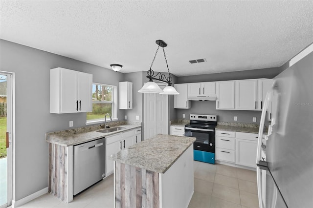 kitchen with white cabinets, a kitchen island, stainless steel appliances, and a sink