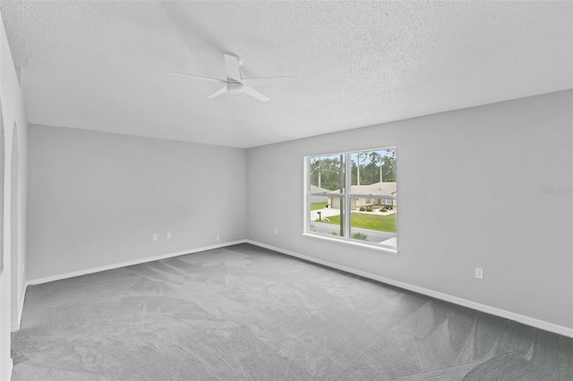 unfurnished room featuring a textured ceiling, carpet flooring, and baseboards