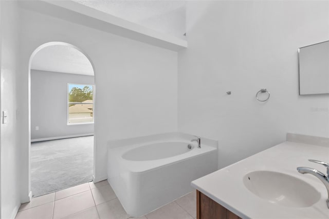 full bath featuring a textured ceiling, vanity, a bath, and tile patterned floors