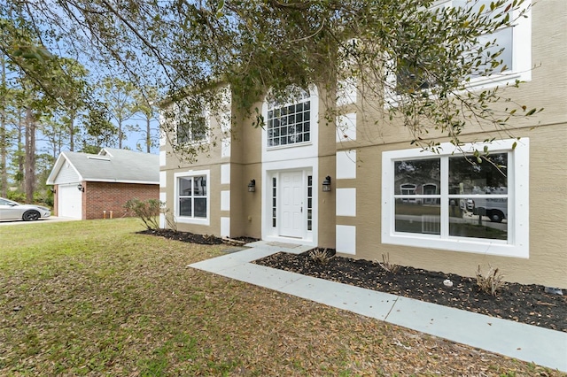 view of front facade with a front yard and stucco siding