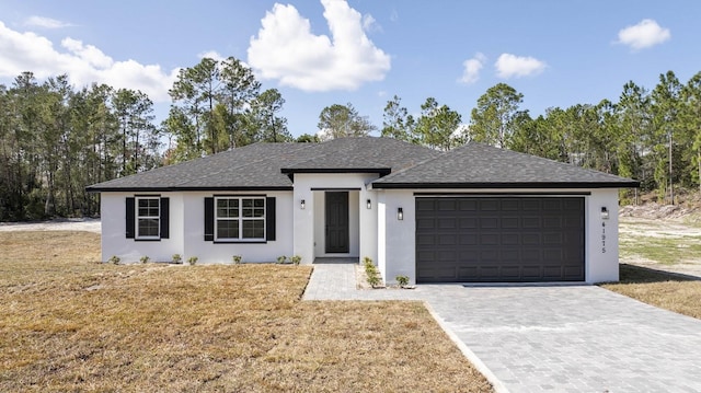 single story home with a garage and a front lawn