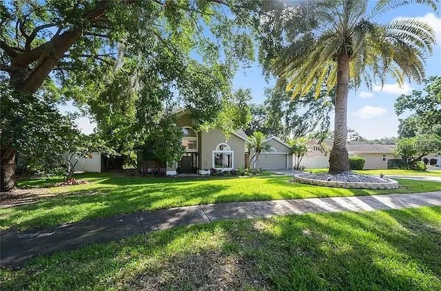 view of front of property with an attached garage, a front lawn, and stucco siding