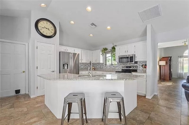 kitchen featuring stainless steel appliances, visible vents, a sink, and decorative backsplash