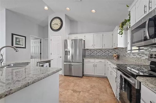 kitchen with stainless steel appliances, light stone counters, a sink, and white cabinets